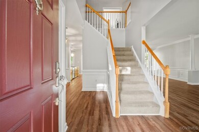 Foyer with ornamental molding and hardwood / wood-