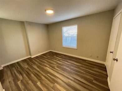 Unfurnished bedroom with dark wood-style flooring
