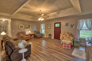 The living room is 21x15. This view is from the dining area of kitchen. The hall to the left leads to the guest bedrooms and  guest bath. The basement door located in the hall.