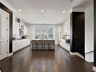 Kitchen with stainless appliances, range hood, a b
