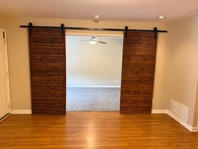 Spare room with a barn door, a textured ceiling, 