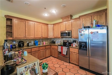 Kitchen featuring decorative backsplash and stainless steel appliances
