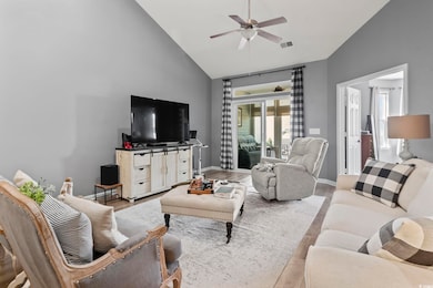 Living area featuring wood finished floors, ceiling fan, and high vaulted ceiling