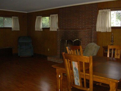 23x14 Den has laminate flooring and a brick firepl