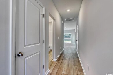 Corridor with light hardwood / wood-style flooring