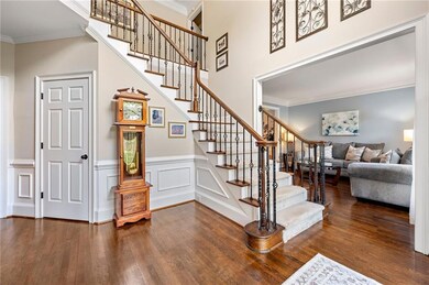 Entryway to the front set of stairs (there are two-one in the front and one in the back) with a spacious closet area under the stairs.  Very creative use of space!  The formal living room is shown to the right of the entrance.