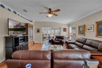 Living room with crown moulding, wood floors, disp