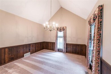 Dining room has newer carpet and vaulted ceiling