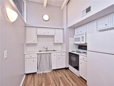Kitchen with a sink, white appliances, light coun