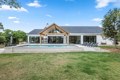 Back of house featuring a yard, a chimney, a pati