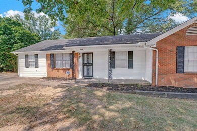 Ranch-style home with a front yard and covered por