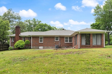 Back of house with a chimney, brick siding, a patio area, roof with shingles, and crawl space