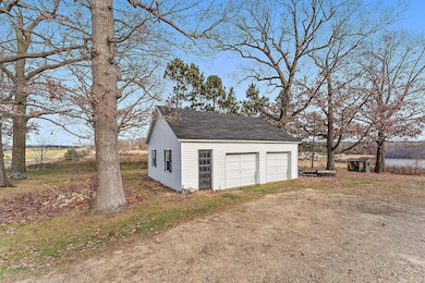 The two car detached garage is nestled among mature trees with ample backyard around and behind it.