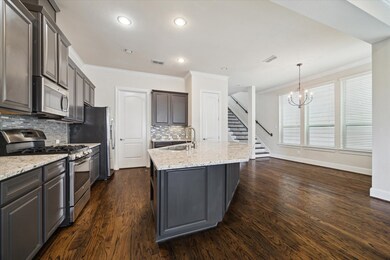 Modern kitchen with dark cabinetry, stainless stee