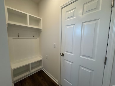 Mudroom featuring dark wood-style floors and baseboards