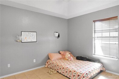 Bedroom featuring light tile patterned floors and baseboards