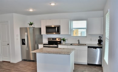 Spacious kitchen provides stainless steel appliances, granite counter tops, laminate flooring.