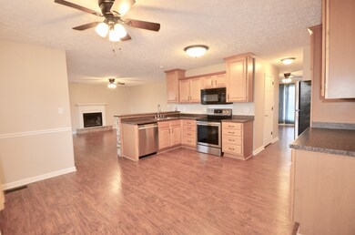 THIS VIEW SHOWS HOW THE CHARMING KITCHEN WITH AN ABUNDANCE OF CABINETRY, OPENS TO THE SPACIOUS FAMILY ROOM.