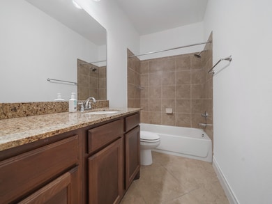 A full bath downstairs with granite countertop and tiled tub/shower combo — perfect for guests or the secondary bedroom downstairs