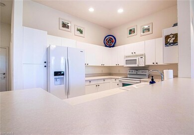 Kitchen featuring white appliances, white cabinetr