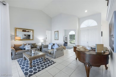 Living room with high vaulted ceiling and light ti