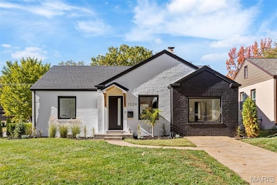 View of front facade featuring brick siding, a front lawn, and a shingled roof