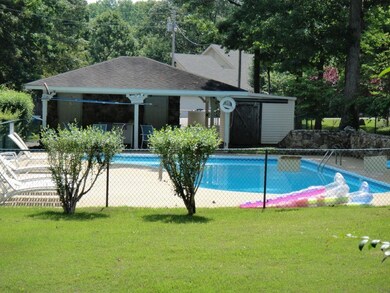 Community pool with a yard, an outdoor structure, 