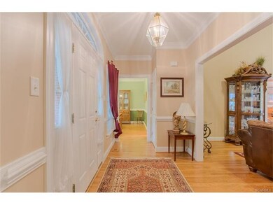 Welcoming Foyer with hardwood floors, crown and ch