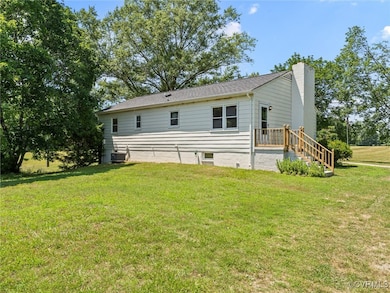 Rear view of house featuring a yard and a chimney