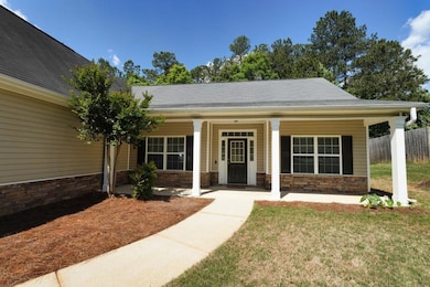 View of front of house with covered porch and ston