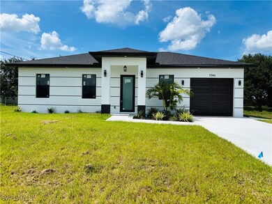 Prairie-style house with driveway, a garage, a front lawn, and stucco siding