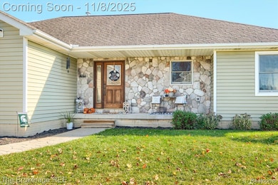 Doorway to property with roof with shingles, a lawn, and stone siding