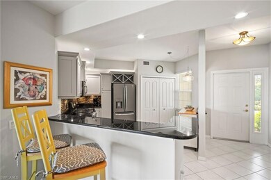 Kitchen featuring stainless steel appliances, a peninsula, gray cabinetry, light tile patterned floors, and tasteful backsplash