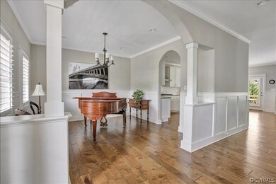 Spacious, open formal dining room has wainscoting.