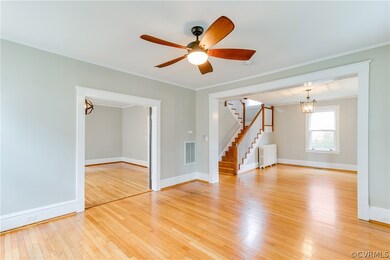 The living room, with new oversized ceiling fan, a continuation of the oak flooring, wide doorways, and a view of both the entryway and dining room, offers plenty of space for family gatherings.