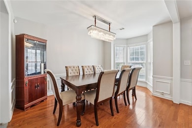 Dining area with plenty of natural light, wood finished floors, and a chandelier