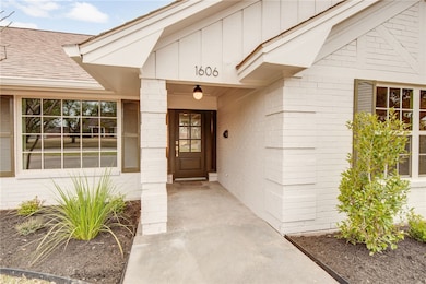 View of exterior entry featuring a shingled roof a