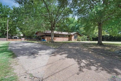 Ranch-style house featuring driveway and stone siding