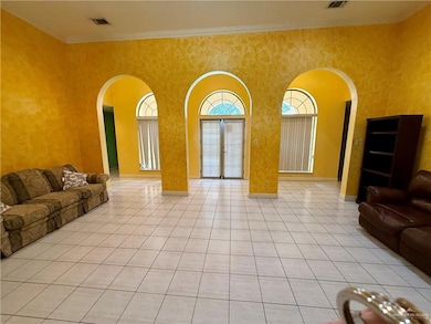 Living Room with arched walkways, light tile patterned floors, a towering ceiling, and crown molding