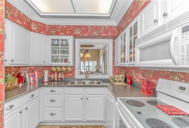 Kitchen with white cabinets, white appliances, and
