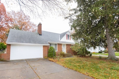 View of front of property featuring a front lawn, a chimney, concrete driveway, and brick siding 7 attached 2 car garage