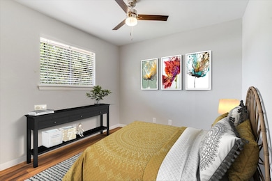 Bedroom with wood finished floors, baseboards, an