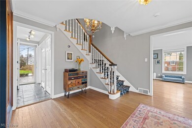 Tiled foyer entrance featuring a wealth of natural light, ornamental molding, and an inviting chandelier