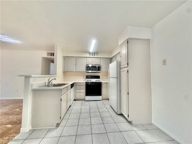 Kitchen with white appliances, a sink, light count