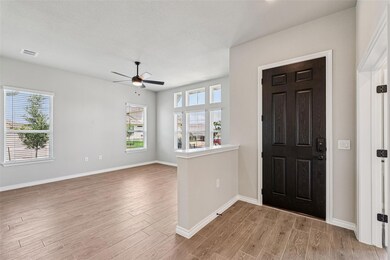Entryway with wood finished floors, a ceiling fan