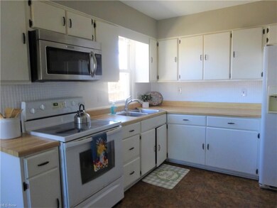 Kitchen with good cabinet space, stove, refrigerator and microwave