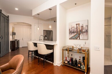 Bar with dark wood finished floors, arched walkway