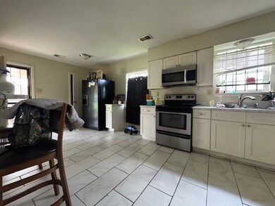 Kitchen with white cabinets, a wealth of natural l