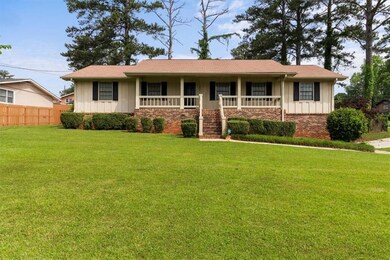 Ranch-style home featuring board and batten siding, a porch, and brick siding