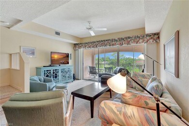 Carpeted living area with a textured ceiling and ceiling fan